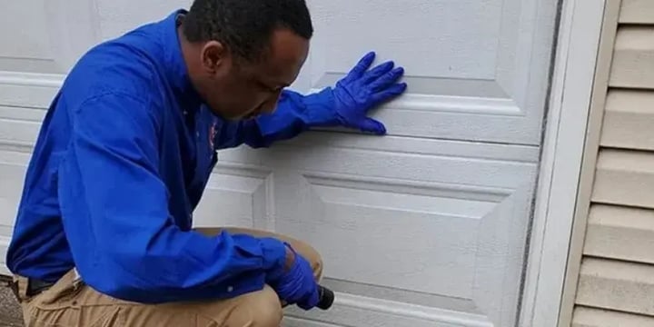 EM Pest Control technician inspecting a garage for rodent entry points