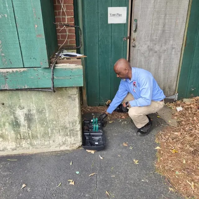 Technician inspecting rodent bait station at warehouse